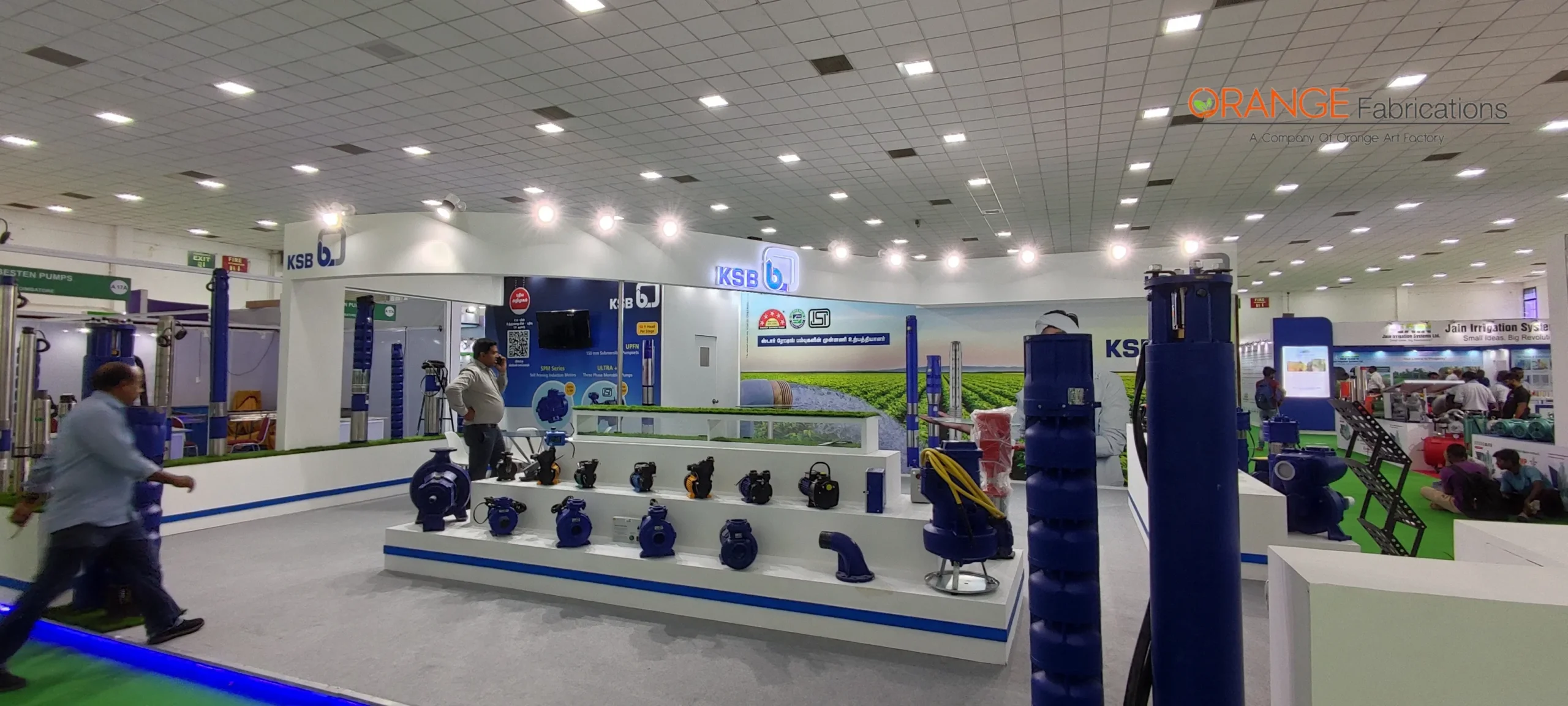 custom wooden exhibition stall with illuminated fascia, interactive digital touch kiosks, and backlit graphic totems fabricated for KSB pumps at CODISSIA Coimbatore